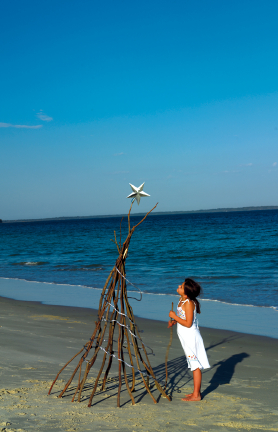 Reaching Out to Families in Sandy Hook Girl on beach looking at driftwood Christmas Tree with star