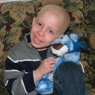 A young boy holding a Ryan's Lion